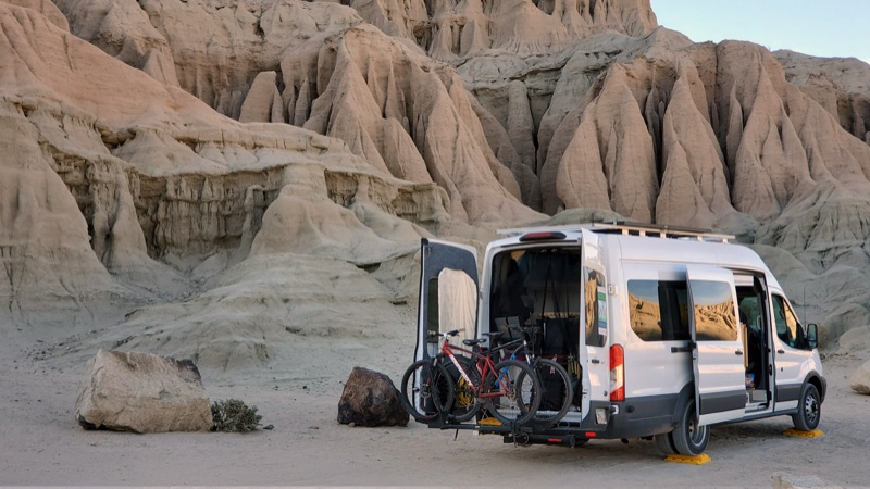 Our white van parked beneath sandstone hoodoos at Red Rock Canyon State Park, California