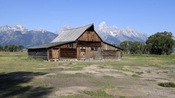 Reference photo — the historic T. A. Moulton Barn, a weathered log barn on Mormon Row with the jagged Teton range rising behind it
